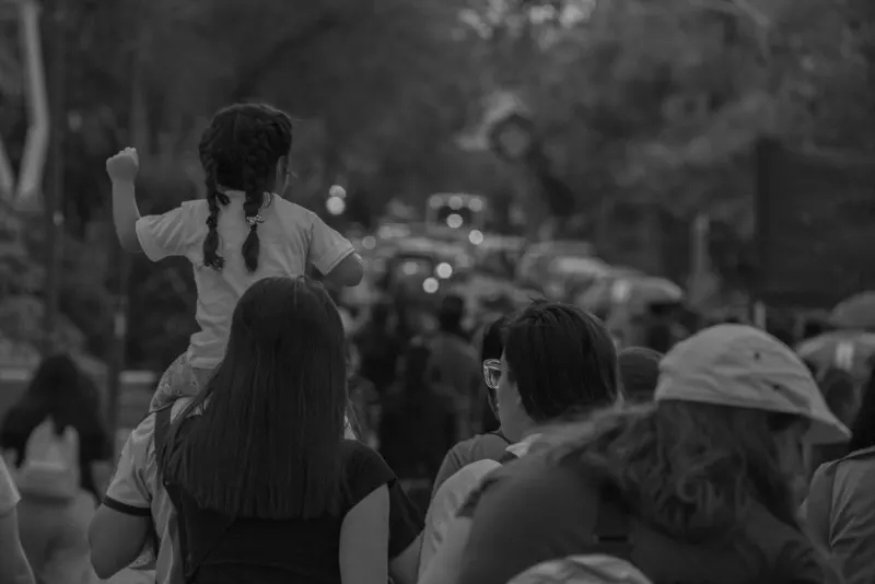 Niña sobre los hombros de una mujer en la marcha