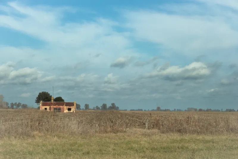 Casa aislada en el campo bajo un cielo amplio