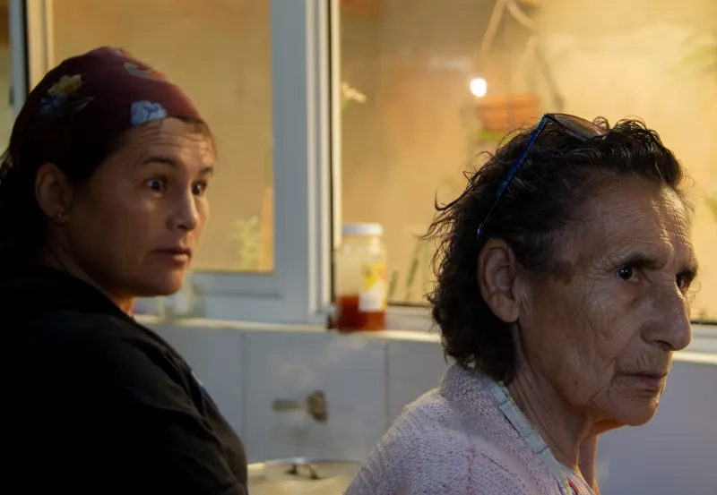 Dos mujeres en una cocina, mirando fuera de cuadro