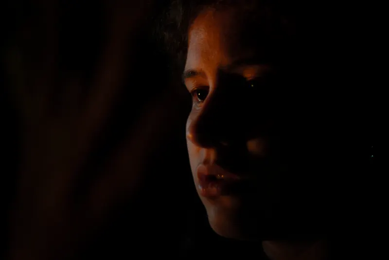 Retrato en claroscuro, con el rostro apenas iluminado