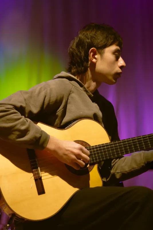 Guitarrista en escena bajo luces de colores