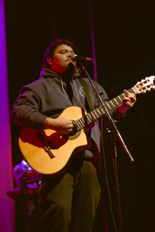 Músico cantando y tocando la guitarra en vivo