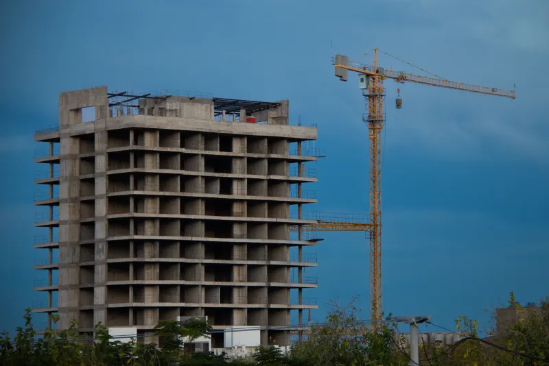 Edificio en construcción con una grúa al atardecer